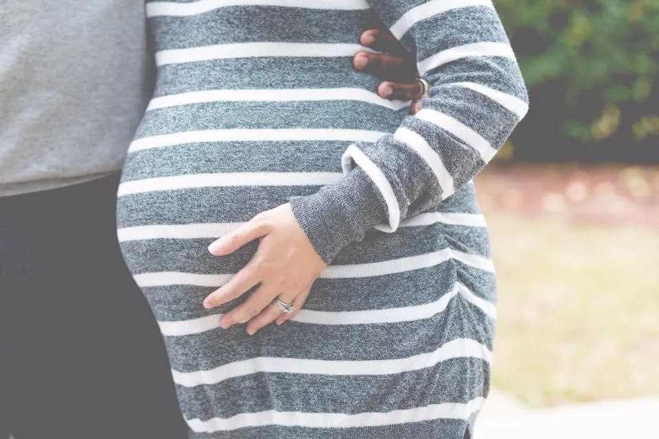 Une future maman pose la main sur son ventre arrondi